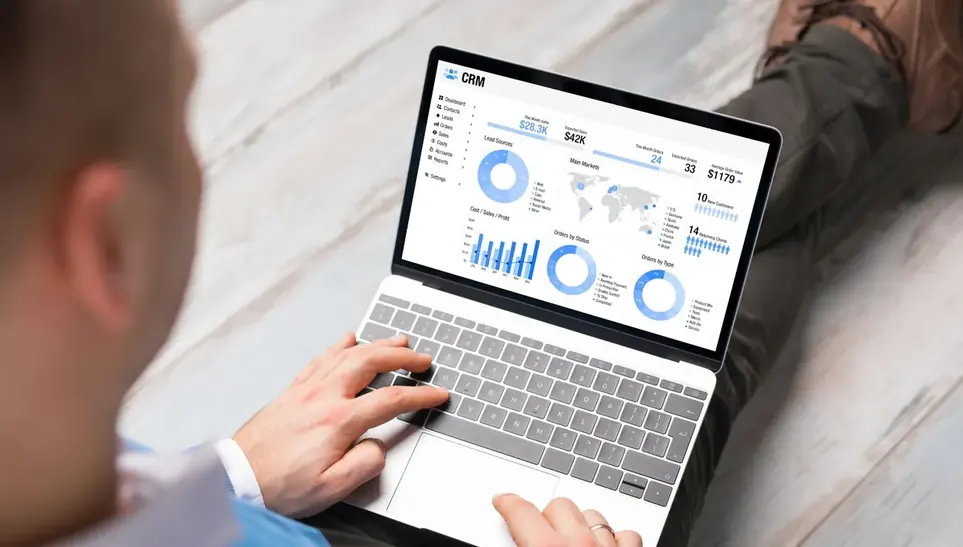 Mãos operando notebook que exibe gráficos de desempenho